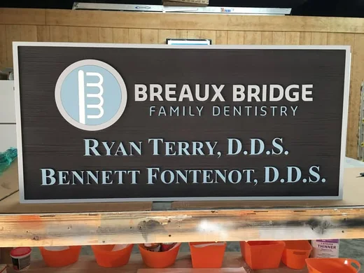 Breaux Bridge Family Dentistry dimensional sign with layered logo, raised lettering and woodgrain background