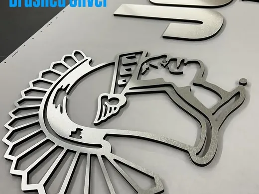 Brushed silver logo components and script dimensional letters before installation