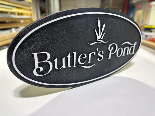 Butler's Pond black and white oval dimensional sign with raised script lettering