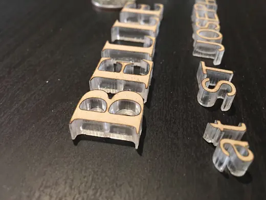 Flat-cut acrylic letters and layered sign components