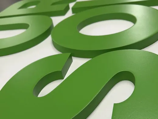 Close-up of thick green dimensional letters showing painted faces and edges