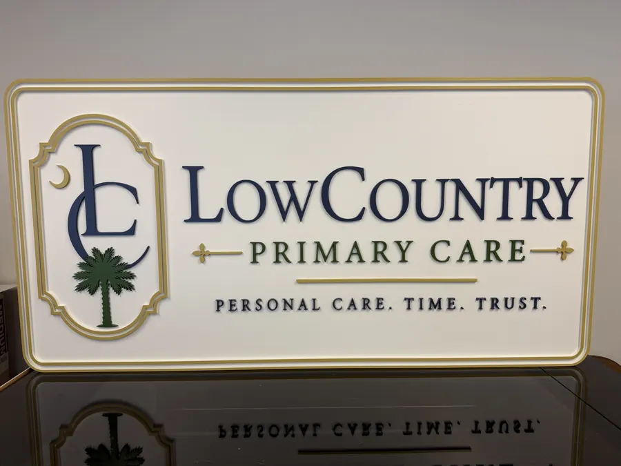 Lowcountry Primary Care finished dimensional sign with a palm tree mark, raised border and gold lettering