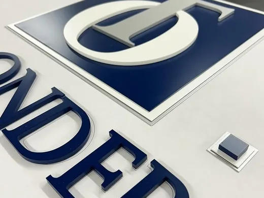 Painted acrylic layers and blue dimensional letters assembled for a custom logo sign