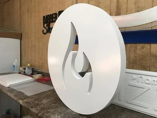 Round dimensional logo sign component standing upright during shop production